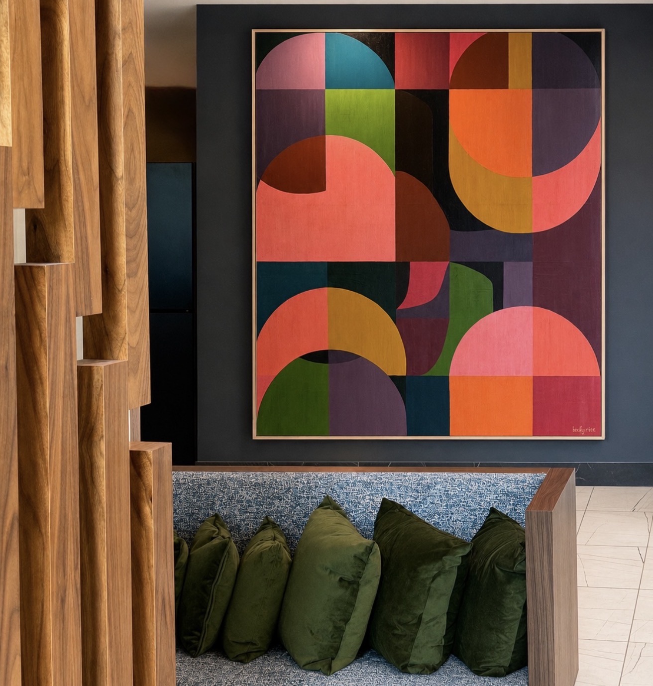 Oversized geometric abstract painting with bold circular color blocks installed in a modern lobby with timber detailing